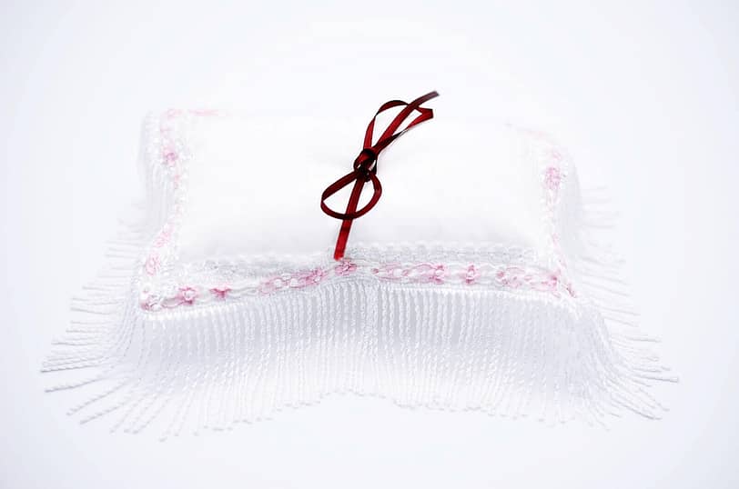 Weißes Ringkissen mit rosa Volant Spitze